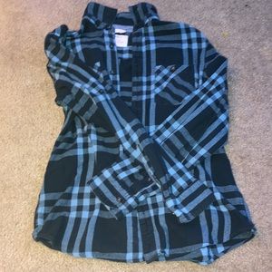 BLUE flannel shirt with black buttoning. Pockets on each side.